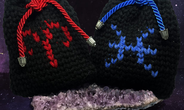 PRODUCT: BAGS SIZE: 4.75” x 5” DESCRIPTION: A handmade knit pouch made of 100% acrylic blend yarn finished with a twisted cord cable with alloy end caps featuring signs Aries and Pisces. All signs available.   PRICE: $15