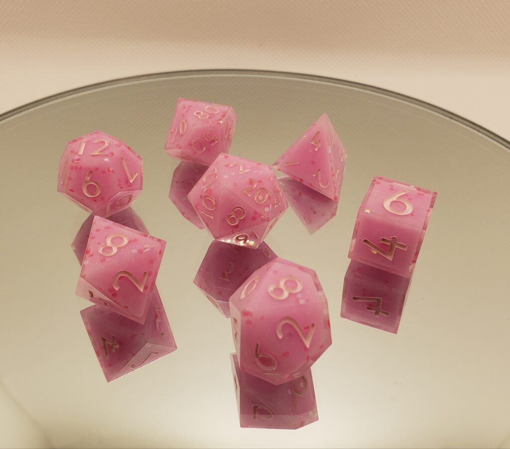Pink dice with gold numbers