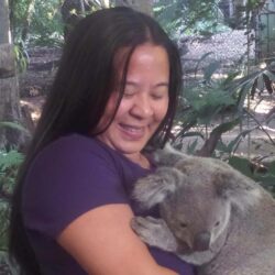 Dark-haired woman holding a koala